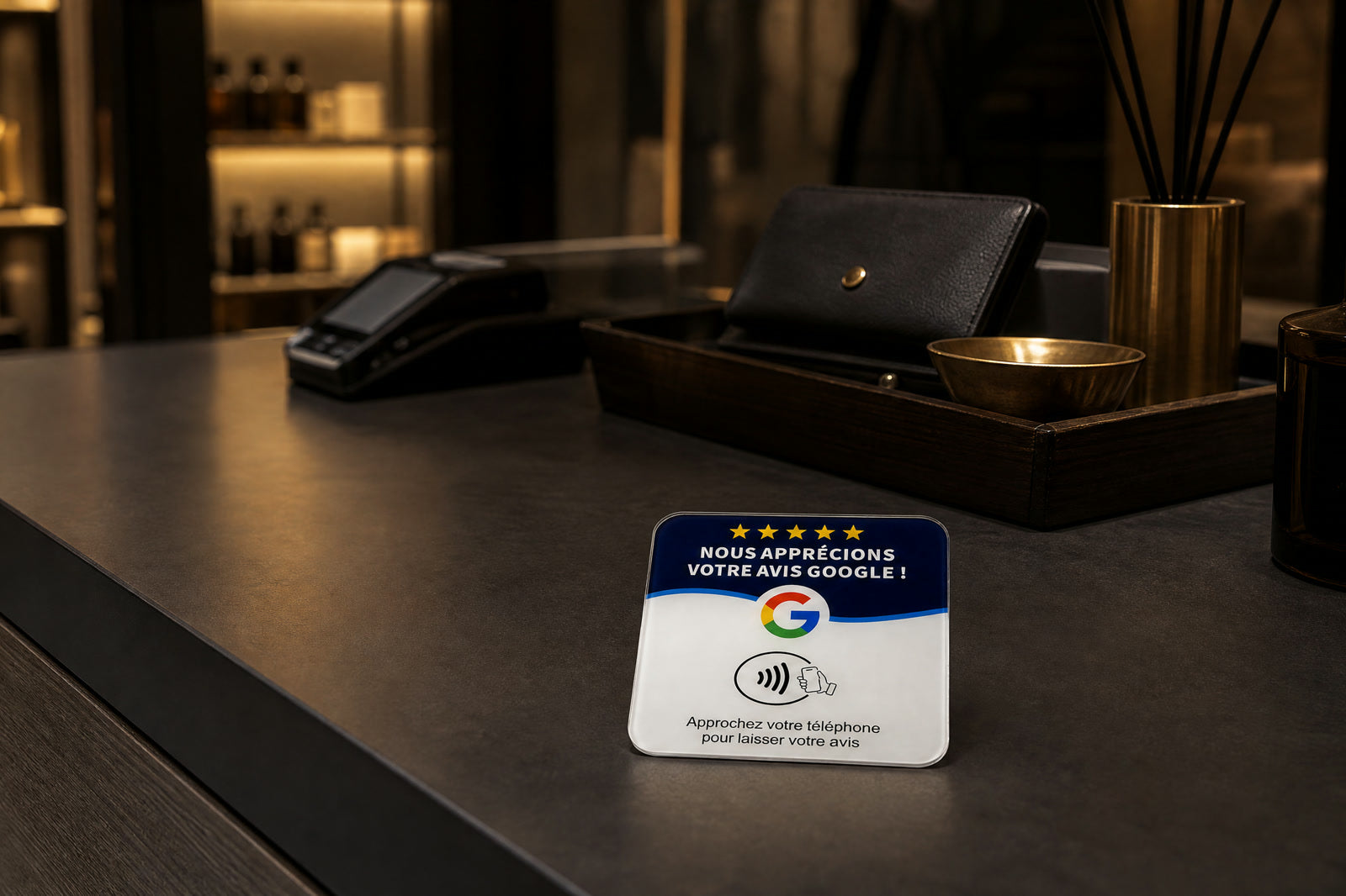 La plaque posée sur le comptoir sombre d'une boutique, près du terminal de paiement.