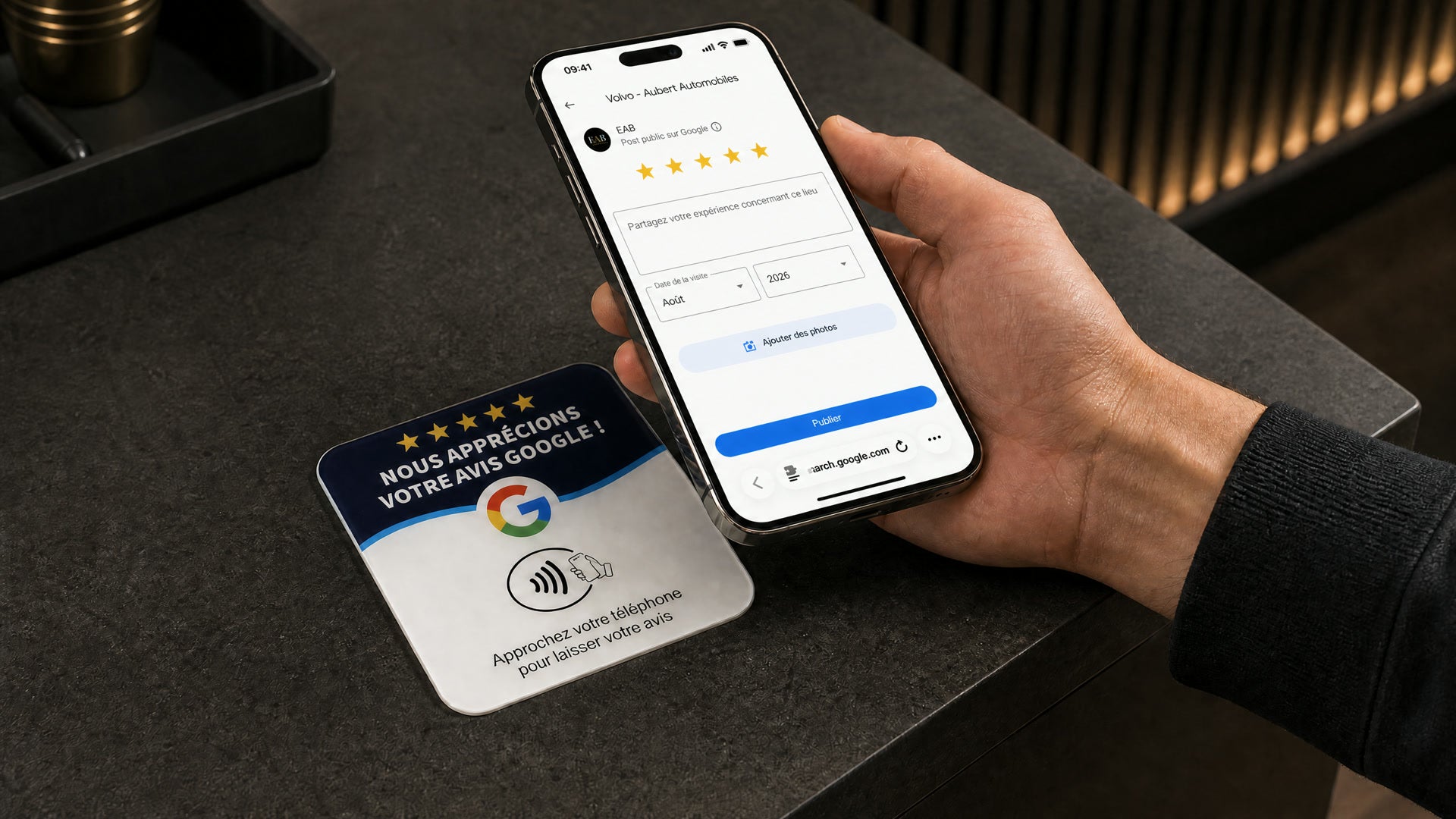 Un client approche son téléphone de la plaque ; sa page d'avis Google s'ouvre.